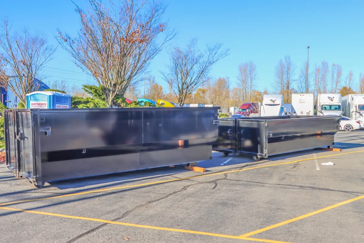 Professional dumpster rental service with roll-off container on residential driveway in Pompton Lakes